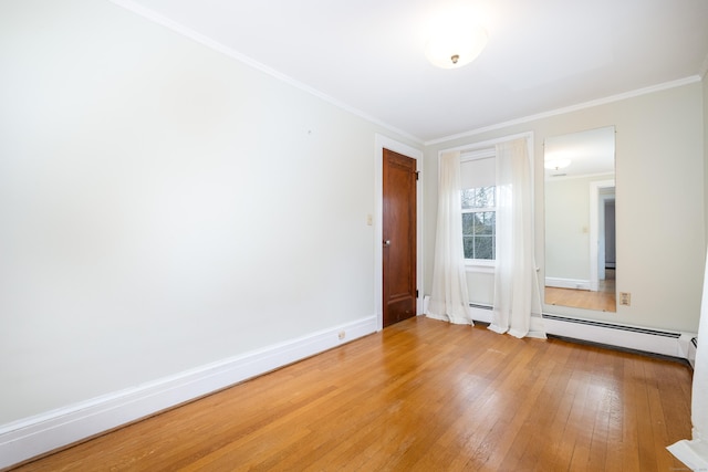 unfurnished bedroom featuring a baseboard heating unit, baseboards, light wood finished floors, and ornamental molding