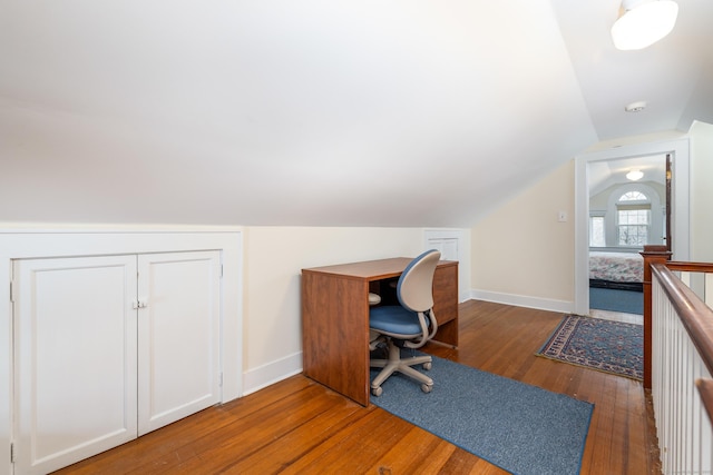 office space featuring baseboards, wood-type flooring, and vaulted ceiling