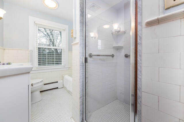 bathroom with a baseboard radiator, toilet, tile walls, and a stall shower