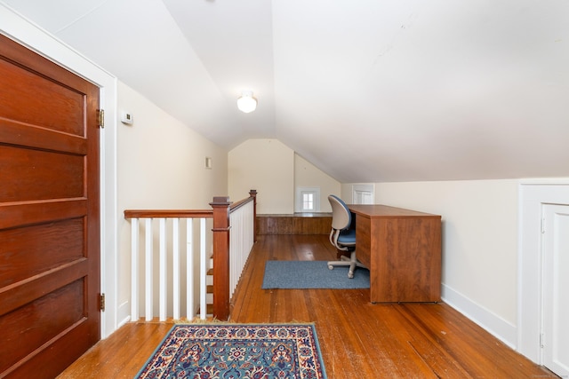 office space featuring hardwood / wood-style flooring, baseboards, and vaulted ceiling