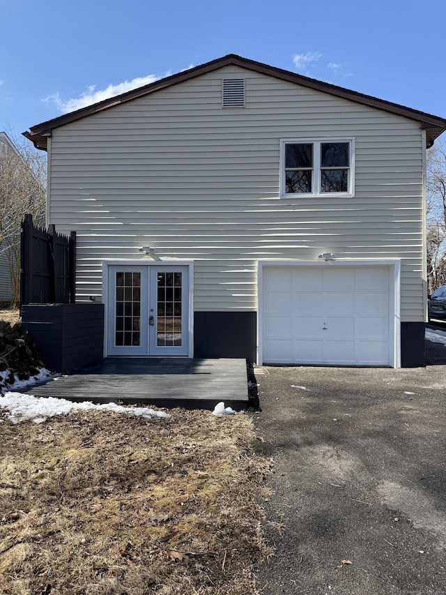 view of side of home with french doors and an attached garage