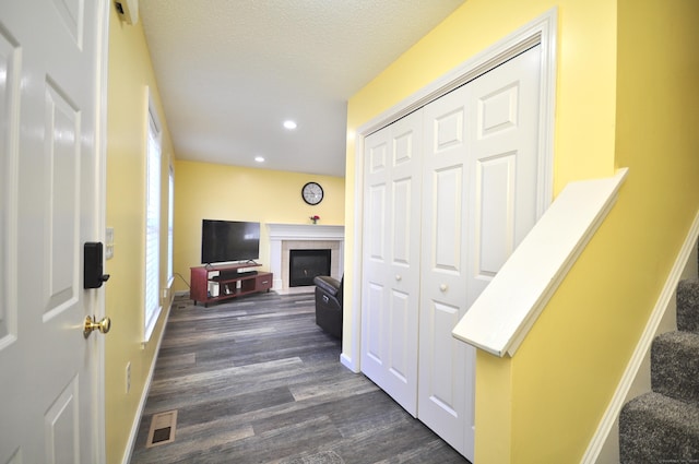 hallway with visible vents, stairs, baseboards, and dark wood finished floors