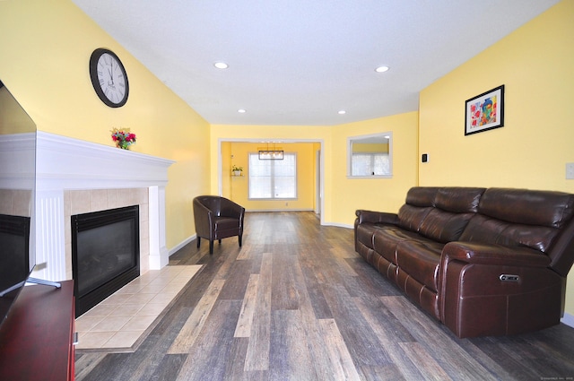 living room with recessed lighting, baseboards, a tiled fireplace, and wood finished floors