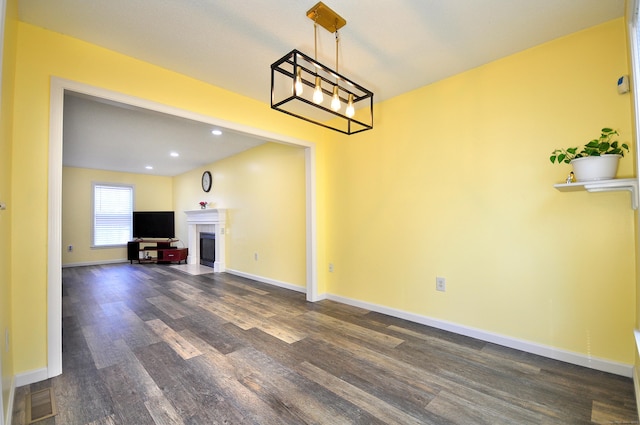 interior space with dark wood-type flooring, a fireplace, recessed lighting, and baseboards