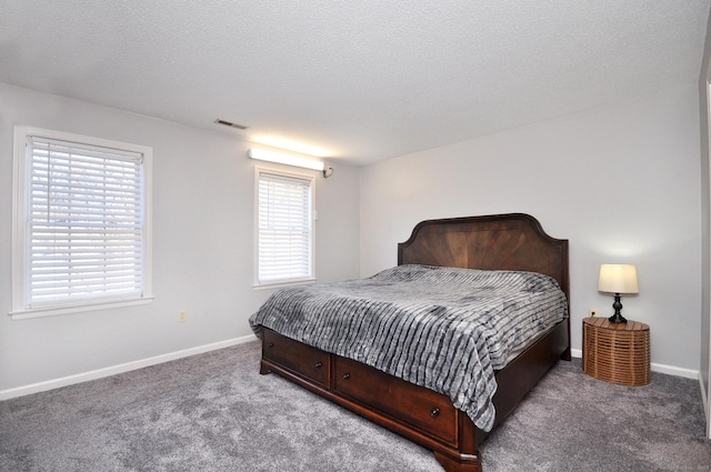 bedroom featuring carpet, visible vents, baseboards, and a textured ceiling