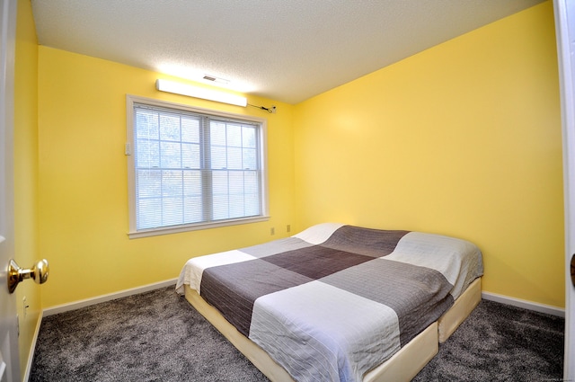 carpeted bedroom featuring a textured ceiling, visible vents, and baseboards