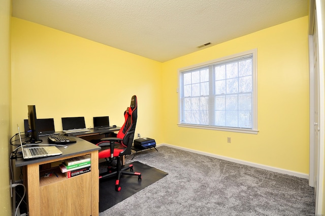 office space with baseboards, a textured ceiling, visible vents, and carpet flooring