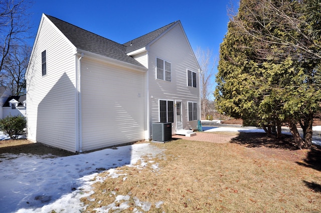 back of property with entry steps, central AC unit, and roof with shingles