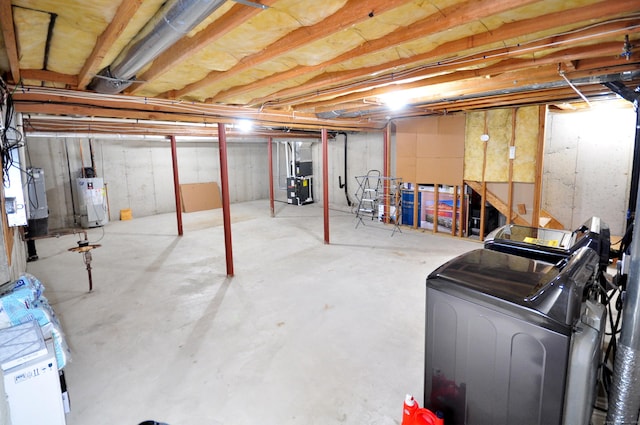 unfinished below grade area featuring water heater, independent washer and dryer, and heating unit