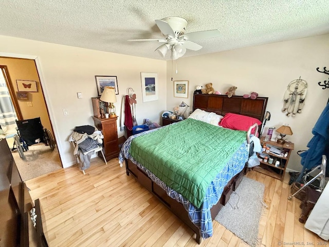 bedroom featuring ceiling fan, a textured ceiling, and wood-type flooring