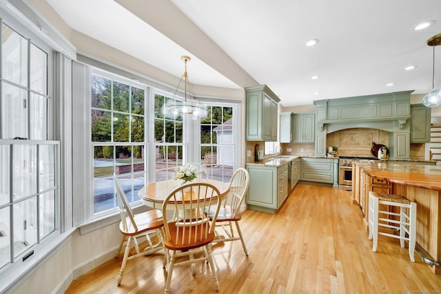 kitchen featuring green cabinetry, tasteful backsplash, a sink, and stainless steel range