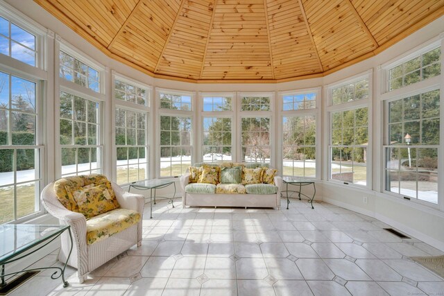 unfurnished sunroom with a healthy amount of sunlight, wooden ceiling, and vaulted ceiling