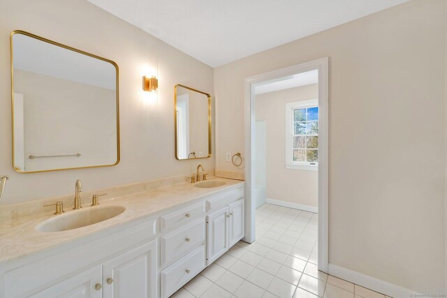 full bathroom featuring double vanity, tile patterned flooring, baseboards, and a sink