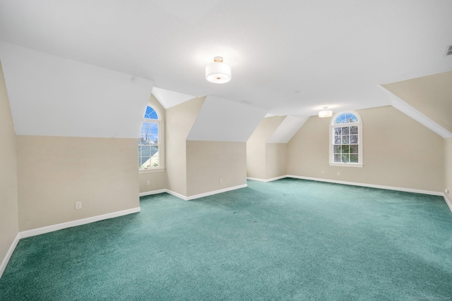 additional living space with plenty of natural light, carpet flooring, baseboards, and vaulted ceiling