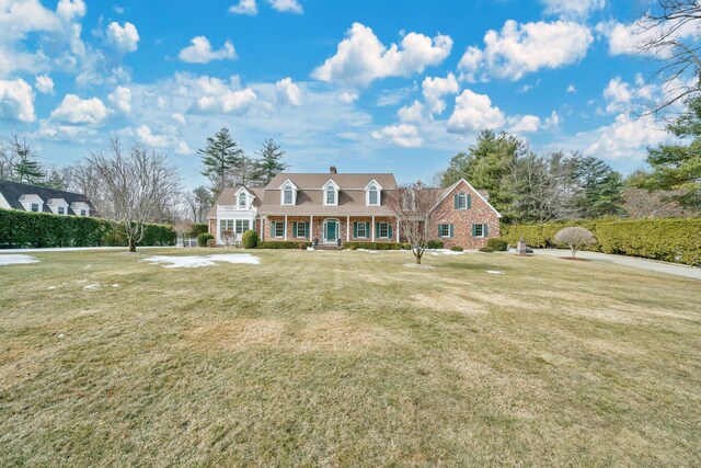 new england style home featuring a front yard