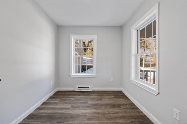 unfurnished room featuring dark wood-type flooring, baseboard heating, a wealth of natural light, and baseboards