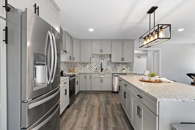 kitchen featuring dark wood-style floors, appliances with stainless steel finishes, backsplash, and gray cabinetry