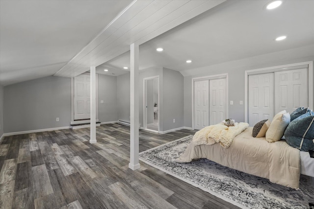 bedroom featuring lofted ceiling, recessed lighting, wood finished floors, baseboards, and two closets