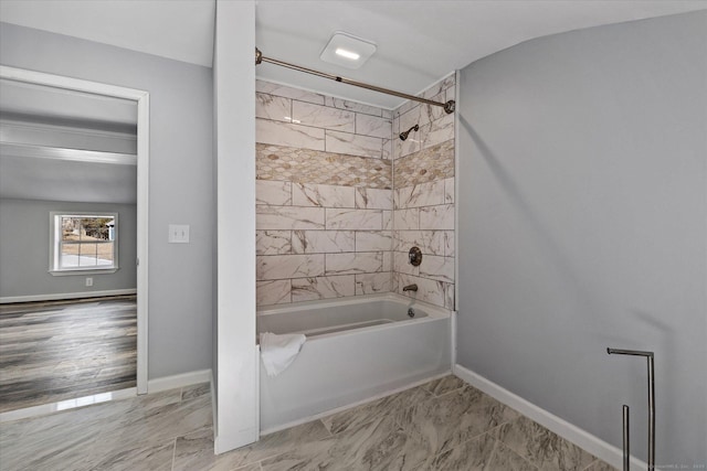 bathroom featuring marble finish floor, shower / bathing tub combination, and baseboards