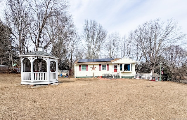 back of house featuring a gazebo and solar panels