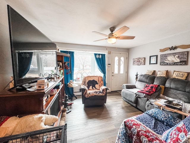 living room featuring a baseboard heating unit, baseboard heating, wood finished floors, and a ceiling fan