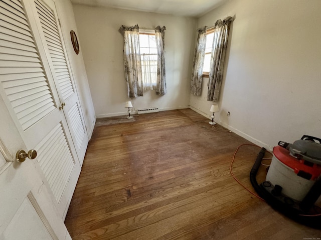 unfurnished bedroom featuring a closet, baseboards, and wood finished floors