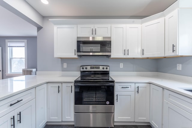 kitchen featuring radiator, appliances with stainless steel finishes, and light countertops