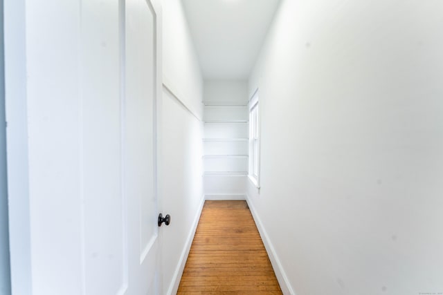 hallway with light wood-style floors and baseboards