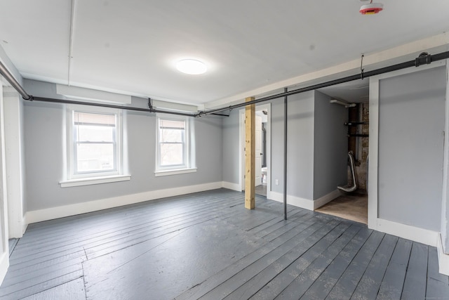 below grade area featuring dark wood-style floors and baseboards