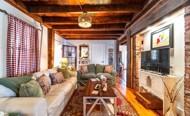 living room featuring beamed ceiling and light wood-type flooring