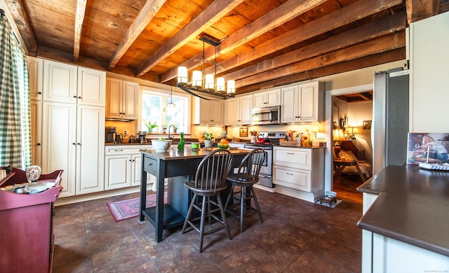 kitchen featuring beam ceiling, a breakfast bar, dark countertops, appliances with stainless steel finishes, and wooden ceiling