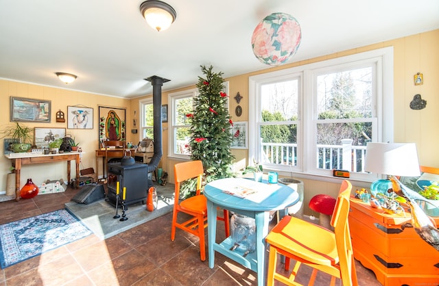 dining space with a wood stove and a healthy amount of sunlight