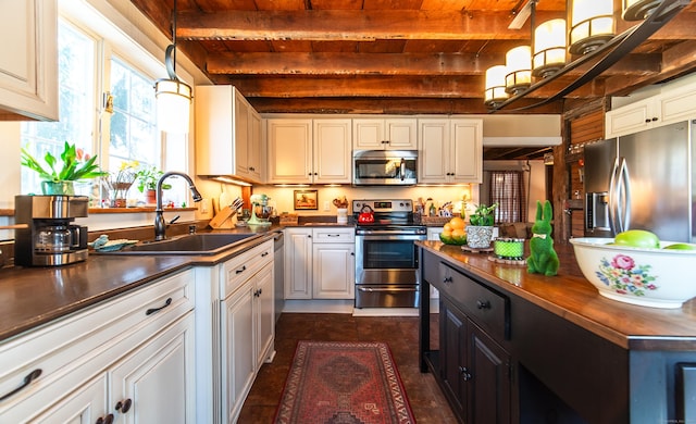 kitchen with beamed ceiling, wooden ceiling, hanging light fixtures, stainless steel appliances, and a sink