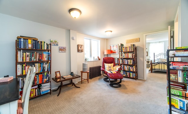 living area featuring plenty of natural light, carpet flooring, radiator heating unit, and baseboards