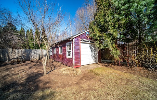 view of outbuilding with an outdoor structure, fence, and dirt driveway