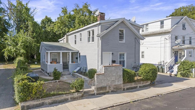 view of front of house with a chimney and fence