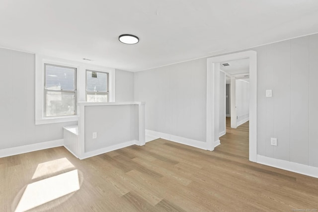 empty room featuring baseboards and wood finished floors