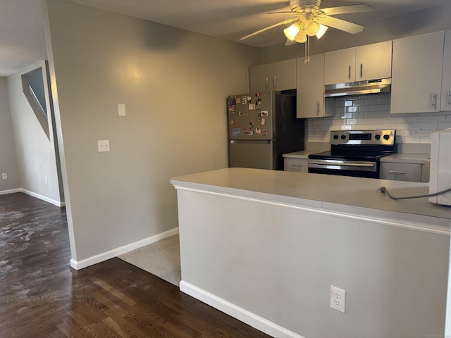 kitchen with under cabinet range hood, stainless steel appliances, a peninsula, light countertops, and decorative backsplash