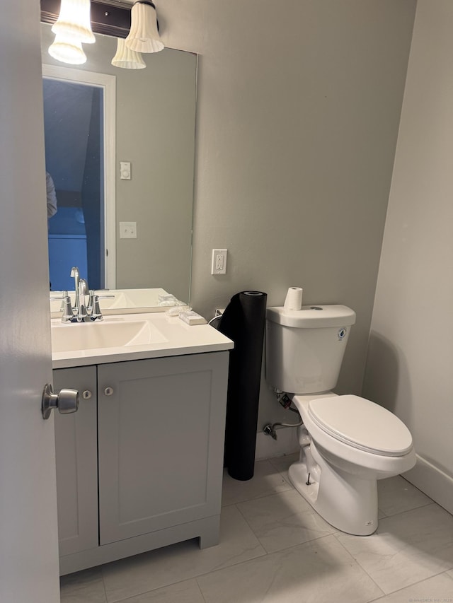 bathroom featuring toilet, marble finish floor, and vanity