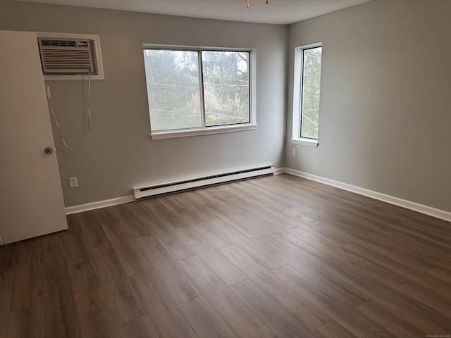 unfurnished room with a textured ceiling, a baseboard heating unit, dark wood-type flooring, baseboards, and a wall mounted AC