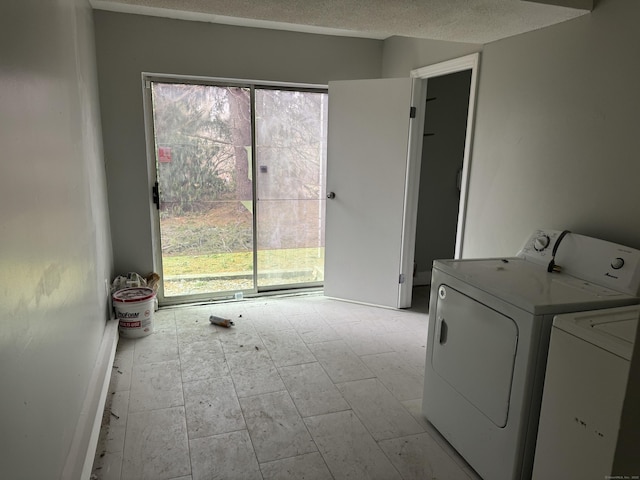 laundry room with a textured ceiling, laundry area, a wealth of natural light, and washer and dryer