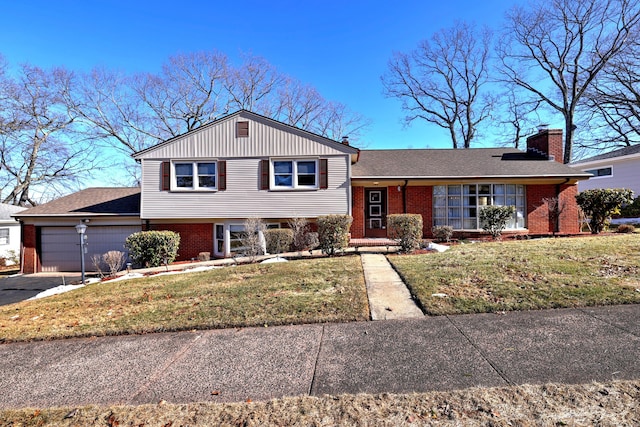 split level home featuring brick siding, an attached garage, a front yard, a chimney, and driveway