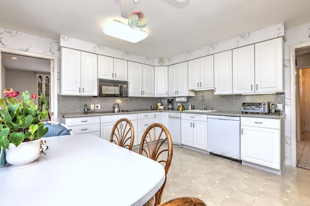 kitchen featuring a sink, decorative backsplash, black appliances, and white cabinetry