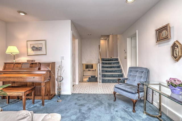 living area with baseboards, carpet floors, and stairs