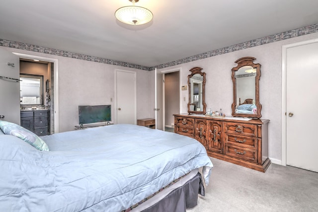 bedroom featuring ensuite bathroom and carpet floors