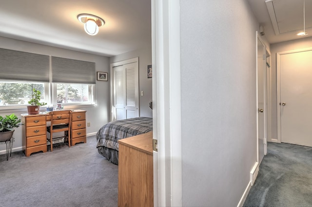 carpeted bedroom featuring a closet, attic access, and baseboards