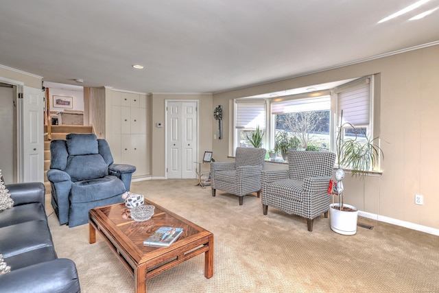 living area featuring visible vents, light colored carpet, baseboards, and ornamental molding