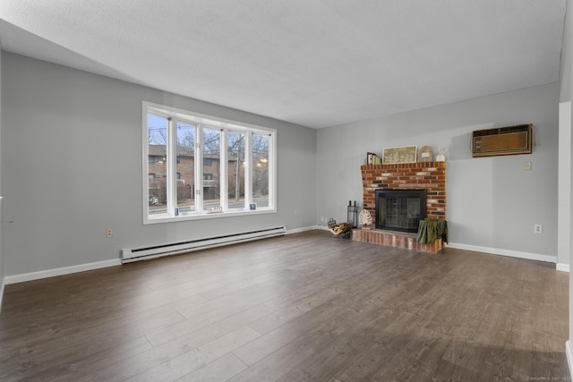 unfurnished living room featuring a wall unit AC, a baseboard radiator, a fireplace, and wood finished floors