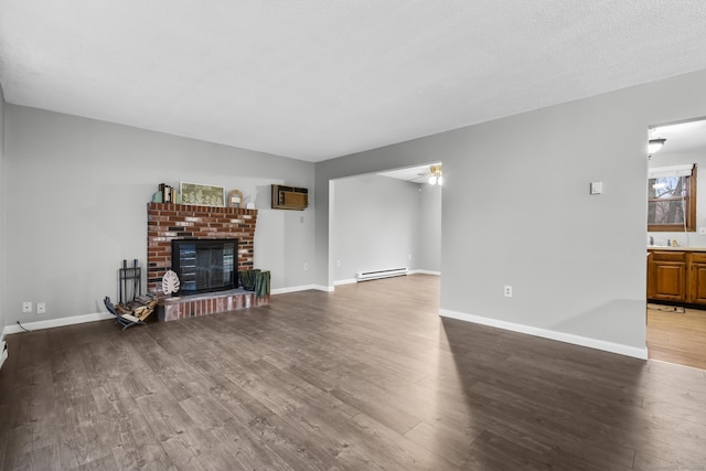 living area featuring a brick fireplace, baseboards, baseboard heating, and wood finished floors