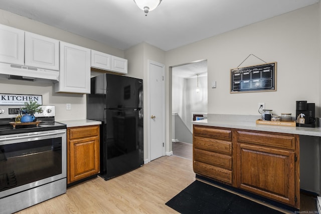 kitchen featuring electric range, light wood-style floors, freestanding refrigerator, and under cabinet range hood